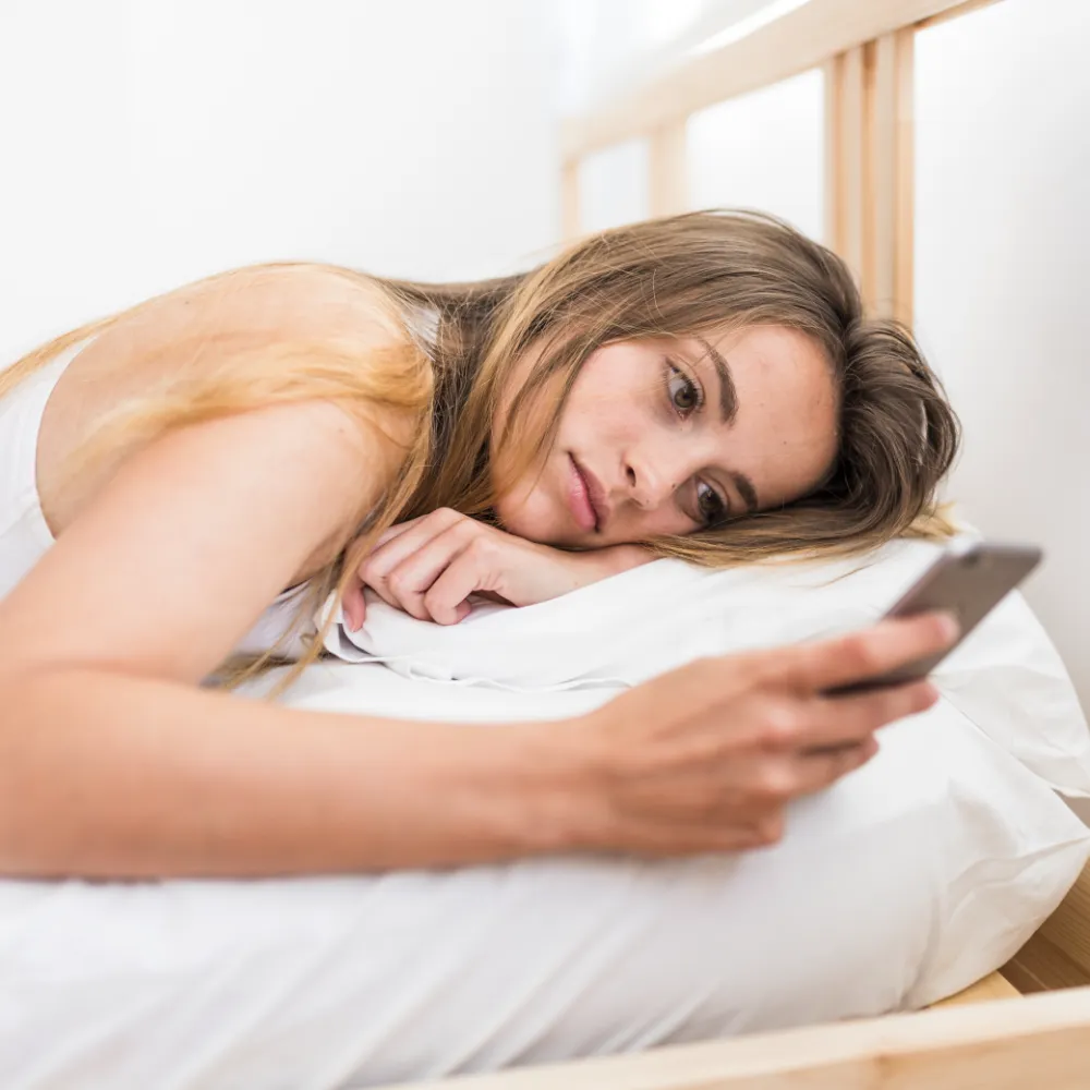 woman lying bed using mobile phone